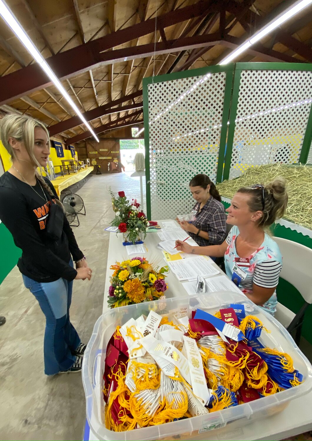 4H Judges Meranda Reynolds and Spencer Merolla quiz Addalyn Strub about her floral design exhibit, Sunday, Aug. 13 at the 136th annual Delaware County Fair.